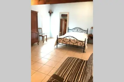 a bedroom with a bed on a tiled floor at Maison spacieuse in Gruissan