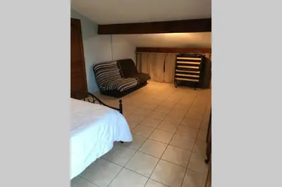 a bedroom with a bed and a couch at Maison spacieuse in Gruissan