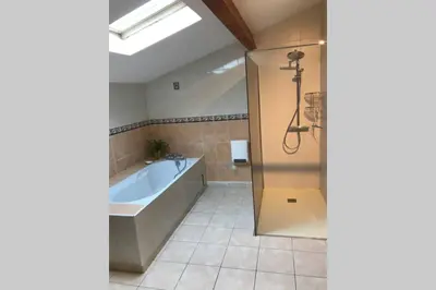 a bathroom with a bath tub and a shower at Maison spacieuse in Gruissan