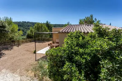 a backyard with a swing and a house at L'Arbre à soleil in Aigues-Vives