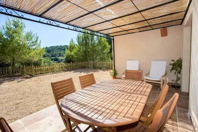 a patio with a table and chairs on a patio at L'Arbre à soleil in Aigues-Vives