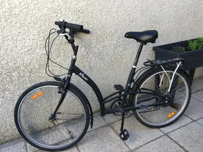 a black bike parked next to a wall at gite echarou Chez Nine in Sigean
