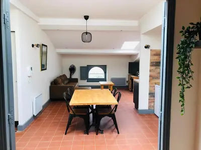 a dining room with a table and chairs and a couch at DOLCE VITA in Carcassonne