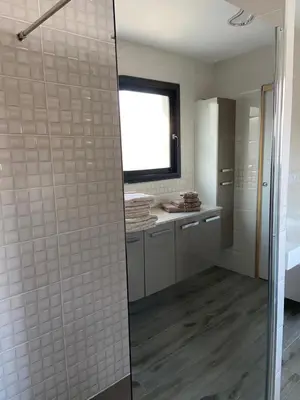 a bathroom with a shower with white tile walls at Fun and sun room in Salles-d'Aude