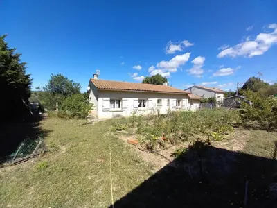 a white house with a garden in front of it at Los olivos in Bize-Minervois