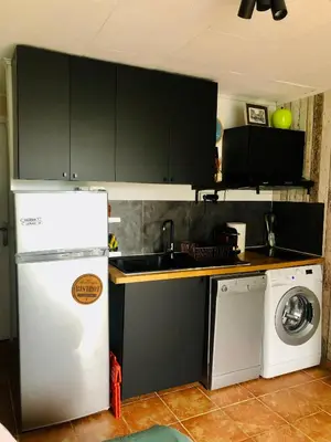 a kitchen with a white refrigerator and a dishwasher at Studio cabine GRUISSAN PLAGE DU GRAZEL in Gruissan