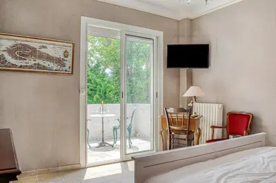 a bedroom with a bed and a view of a patio at Les Vignes de Carcassonne - Classé 4 étoiles Piscine et clim in Capendu