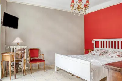 a bedroom with a white bed and a red wall at Les Vignes de Carcassonne - Classé 4 étoiles Piscine et clim in Capendu