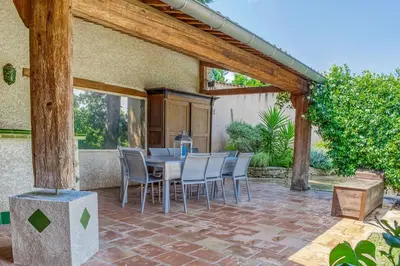 a patio with a table and chairs on a brick patio at Les Vignes de Carcassonne - Classé 4 étoiles Piscine et clim in Capendu