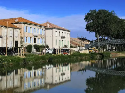 a group of buildings next to a river at Les Volets Bleus in Sallèles-dʼAude