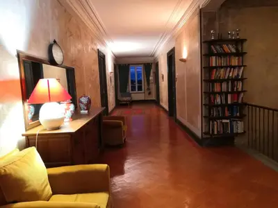 a living room with a couch and a lamp on a table at Les Volets Bleus in Sallèles-dʼAude