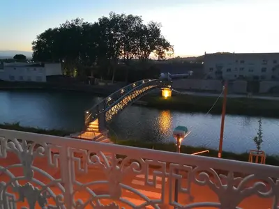 a bridge over a body of water at sunset at Les Volets Bleus in Sallèles-dʼAude