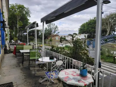 a patio with tables and chairs on a balcony at Les Volets Bleus in Sallèles-dʼAude