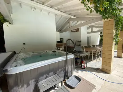 a hot tub in a patio with a table and chairs at Manoir et Appartements avec piscine au Domaine de Bize Mirepoix in Mirepoix