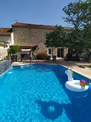 a swimming pool with an inflatable pool noodle in front of a house at Loft au bord du Canal du Midi in Roubia