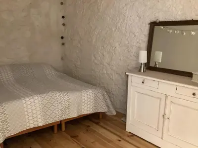 a bedroom with a bed and a mirror and a dresser at Loft au bord du Canal du Midi in Roubia