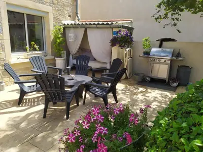 a patio with chairs and a table and a stove at Loft au bord du Canal du Midi in Roubia