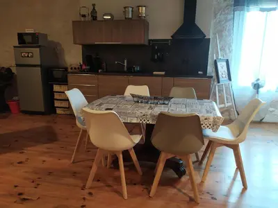 a table and chairs in a kitchen with a table and a kitchen at Loft au bord du Canal du Midi in Roubia