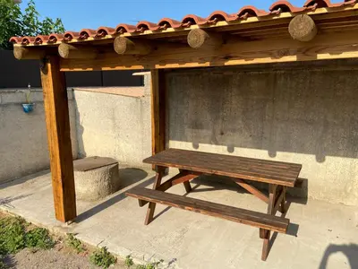 a wooden picnic table under a gazebo at Maison vivancos in Narbonne