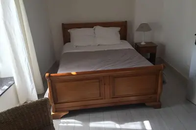 a bedroom with a bed with a wooden frame and pillows at La casa Trivala in Carcassonne