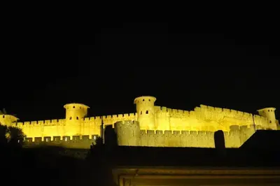 a large castle is lit up at night at La casa Trivala in Carcassonne