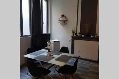 a dining room table with black chairs and a fireplace at restez zen in Carcassonne
