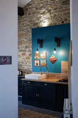 a kitchen with a sink and a blue wall at Gîte Esprit Loft Proche de Narbonne in Mirepeisset