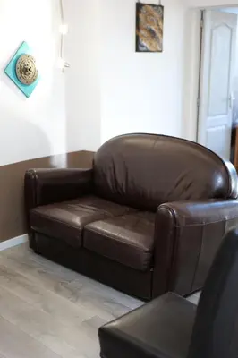 a brown leather couch sitting in a living room at Gîte Esprit Loft Proche de Narbonne in Mirepeisset