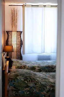 a bedroom with a bed and two windows at Gîte Esprit Loft Proche de Narbonne in Mirepeisset
