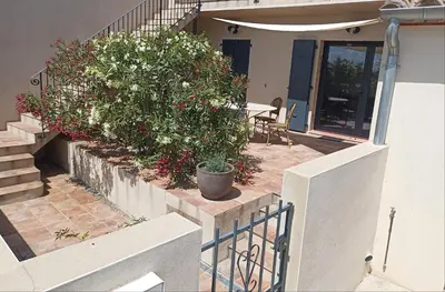 a house with a staircase and some bushes and flowers at l-Ostalet in Bages
