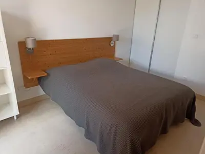 a bed in a room with a wooden headboard at l-Ostalet in Bages