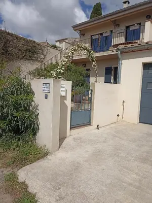 a house with a blue door and a fence at l-Ostalet in Bages