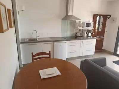 a kitchen with a wooden table and a kitchen with a couch at l-Ostalet in Bages