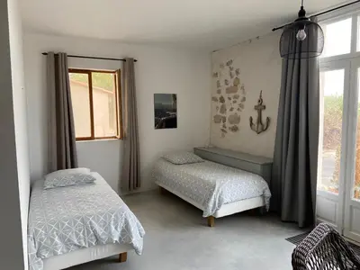 a bedroom with two beds and a window at Parenthèse au bord de l’étang in Bages