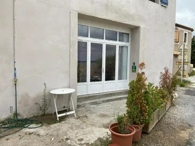 a white door with a table and some plants at Parenthèse au bord de l’étang in Bages