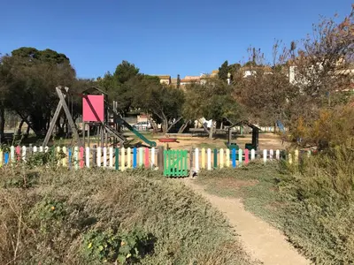 a fence in a park with a playground at Parenthèse au bord de l’étang in Bages