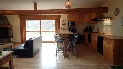 a kitchen with a table and chairs in a room at Gîtes Le Paradoxe des Pyrénées in Montferrier