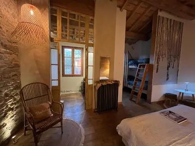 a room with a bed and a chair and a table at Logis Hotel Nature Cathare in Léran