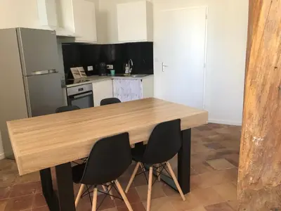a kitchen with a wooden table and four chairs at Coup de cœur 4 étoiles en hyper centre, gare immédiate et canal du midi à 2 pas in Castelnaudary