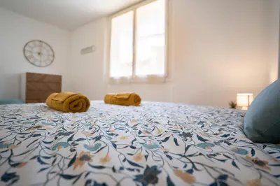 a bed with two towels on top of it at Maison La Majorelle - 90m2 - Garage et Terrasse in Pamiers