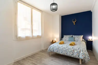a bedroom with a bed with a blue wall at Maison La Majorelle - 90m2 - Garage et Terrasse in Pamiers