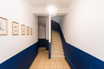 a hallway with stairs and a blue and white wall at Maison La Majorelle - 90m2 - Garage et Terrasse in Pamiers
