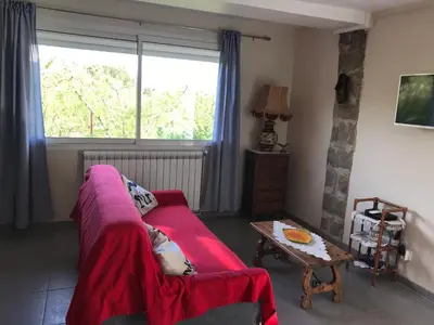 a living room with a red couch and a table at Els Pirineus in Molitg les Bains
