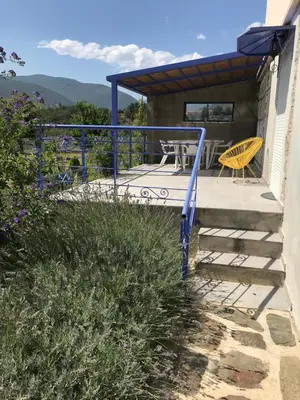 a house with a deck with a table and chairs at Els Pirineus in Molitg les Bains
