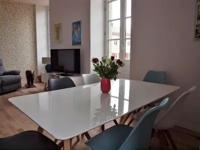 a white dining room table with a vase of flowers on it at Gites de l'écluse 