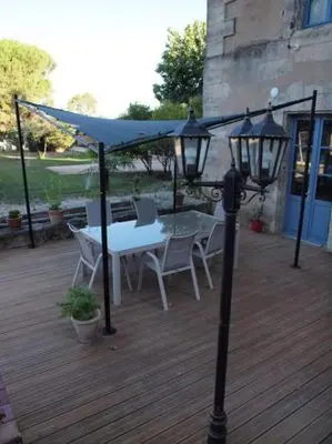 a table and chairs under an umbrella on a deck at Gites de l'écluse 