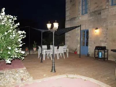 a patio with a table and chairs and a street light at Gites de l'écluse 