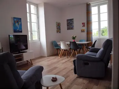 a living room with a couch and chairs and a tv at Gites de l'écluse 