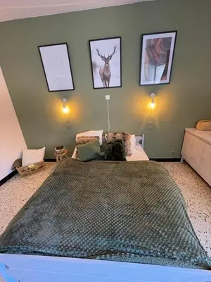 a bedroom with a bed with a dog sitting on it at Chez Tatie Ménie in Fraissé-des-Corbières