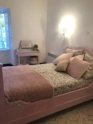 a bedroom with a bed and a table with a laptop at Chez Tatie Ménie in Fraissé-des-Corbières